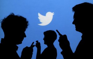 People holding mobile phones are silhouetted against a backdrop projected with the Twitter logo in this file illustration picture taken in Warsaw September 27, 2013. Social media power Twitter Inc plans to announce the departure of some major executives on January 25, 2016, technology news website Re/code reported on Sunday, citing sources. REUTERS/Kacper Pempel/Files