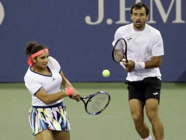 Sania Mirza, of India, returns a shot to Taylor Townsend and Donald Young during a mixed doubles match in the U.S. Open tennis tournament, Friday, Sept. 2, 2016, in New York. Mirza's teammate Ivan Dodig, of Croatia, looks on. (AP Photo/Darron Cummings)